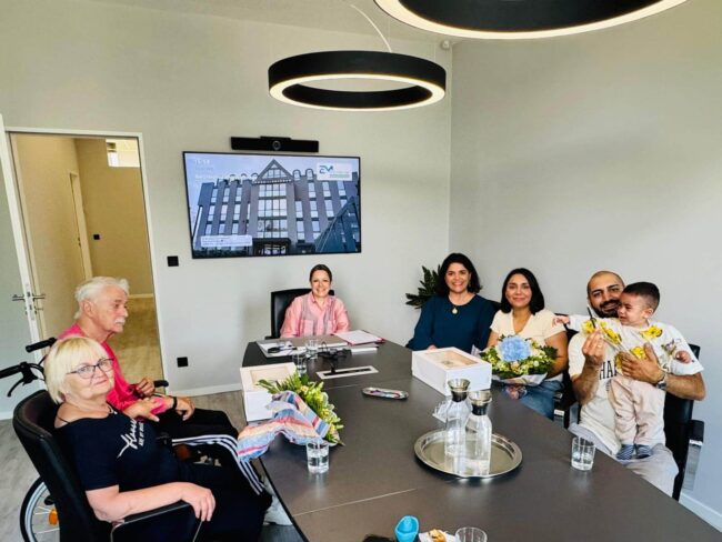 Vertrauensvoller Abschluss beim Notar ✍️: Junge Käufer 👩‍💼👨‍💼 und langjährige Eigentümer 🧓👵 besiegeln den erfolgreichen Immobilienverkauf 🏡 – ein besonderer Moment für alle Beteiligten 🤝✨